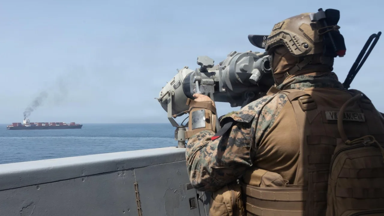 Military-Monitoring-Cargo-Ship-Strait-of-Hormuz Military personnel monitoring a commercial cargo ship in the Strait of Hormuz amid the Iran ceasefire offer.